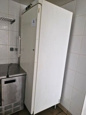 a small refrigerator in the corner of a small kitchen