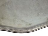an antique silver plate with a scalloped edge on a white background