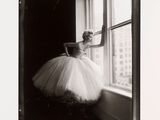 photographie en noir et blanc d'une femme en tutu posant devant une fenêtre