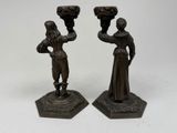 pair of bronze figurines of a man and a woman holding vases