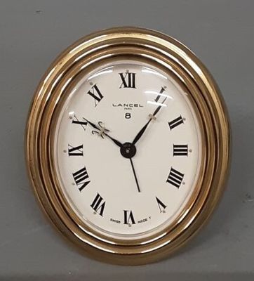 LANCEL : Pendulette en laiton de forme ovale.