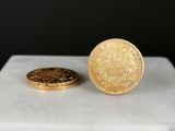 deux pièces d'or posées sur un bloc de marbre blanc