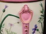 a pink vase with a bird and flowers painted on it