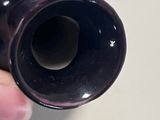 a person holding a black vase in their hand