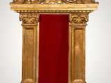 an ornate gold frame with a red velvet covering