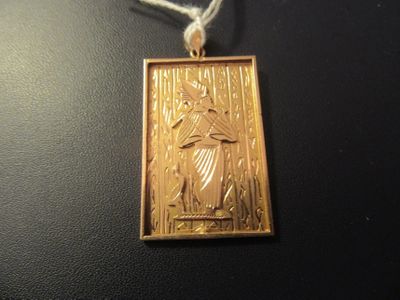 a picture of a gold pendant with a picture of jesus on it