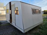 a small white trailer parked on the side of the road