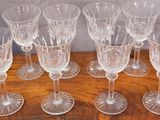 six clear wine glasses sitting on top of a wooden table