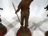 three bronze figurines of a boy and a girl on a pedestal