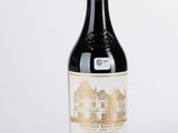 une bouteille de vin rouge posée sur une table blanche