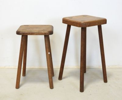 two wooden stools sitting next to each other against a white wall