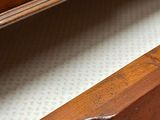 a close up of a wooden dresser with a drawer underneath it