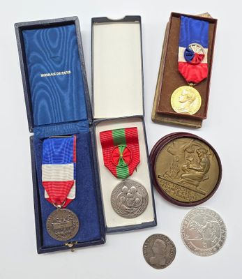 trois médailles et une médaille dans une boîte posée sur une table