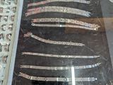 une vitrine en verre dans laquelle sont exposés plusieurs types de couteaux