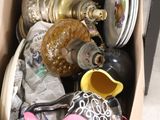 une boîte remplie d'objets hétéroclites posée sur le sol