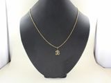 a gold necklace with a small initial on a black mannequin