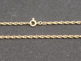 gold plated necklace with a long chain on a black surface