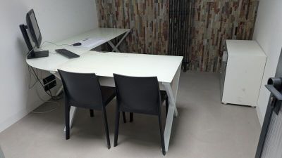 un bureau avec deux chaises et un ordinateur dessus