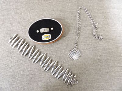 un collier en argent et un peigne en argent posés sur une table