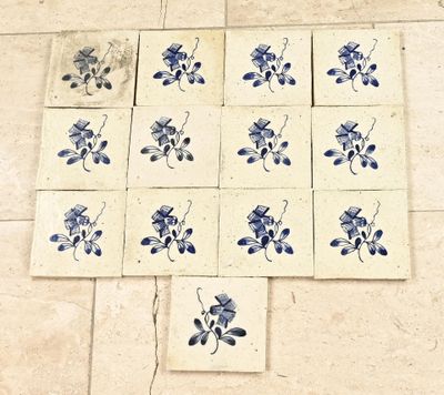 des carreaux bleus et blancs ornés de fleurs bleues, posés sur un sol carrelé