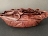 brown leather purse on table with grey background