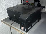 a printer sitting on top of a shelf in a room