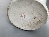 a white vase with red writing on it sitting on a table