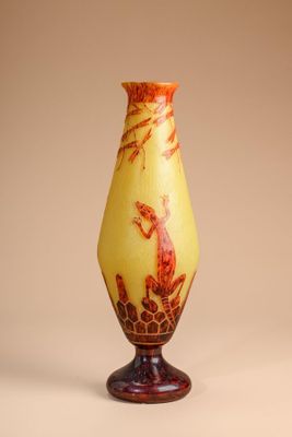 a yellow vase with a bird on it on a stand