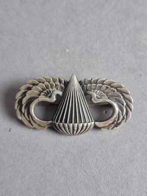 une image représentant une broche en argent surmontée d'un oiseau