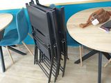 several chairs and a table in a room with a blue wall
