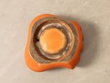 a small orange object with a hole in the middle