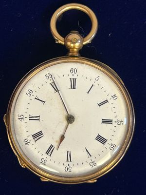 une montre de poche en or avec des chiffres romains sur le cadran