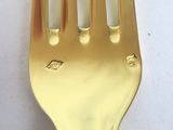 a gold fork that is sitting on a white table