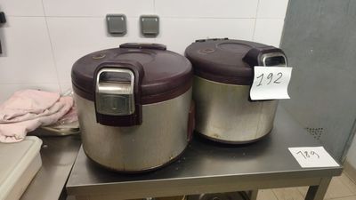 two rice cookers sitting on a table in a kitchen