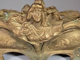 a gold statue of a woman sitting on top of a bowl