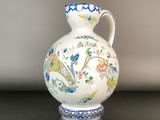 un vase blanc orné d'un motif bleu et jaune