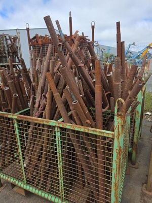 un gros tas de tuyaux métalliques rouillés dans une cage