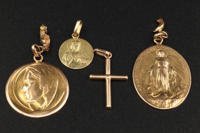 three gold medals and a cross on a black surface