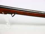 the rifle is on display on a clear stand