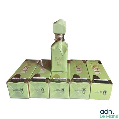 an image of a bottle of perfume sitting on top of a stack of boxes