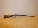 Un vieux fusil est posé sur une table près d'un mur.