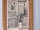 an old picture of a man in a military uniform standing in front of a clock