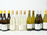plusieurs bouteilles de vin sont alignées sur une surface blanche