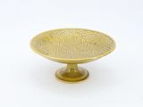 brass footed bowl with a floral design on a pedestal