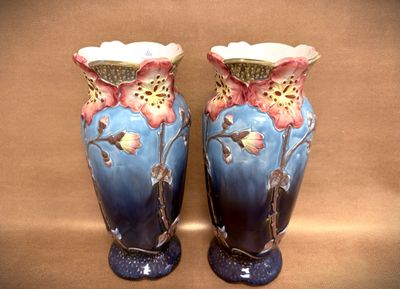two blue vases with flowers on them on a table