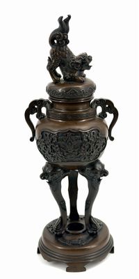 a bronze urn with a peacock on it