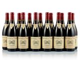 six bottles of wine lined up in a row on a white surface