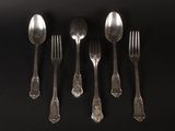 five silver spoons and two silver spoons on a black table