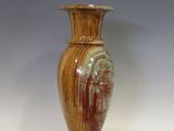 un vase brun posé sur une table à fond blanc