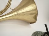 a gold horn and a black object on a white table